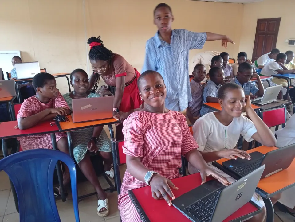 A Techbase instructor helping a pupil at a laptop