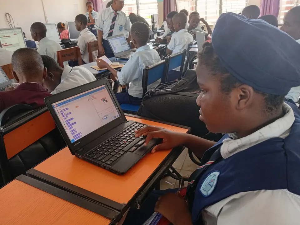 A student building a Scratch project on a laptop in a Lagos classroom