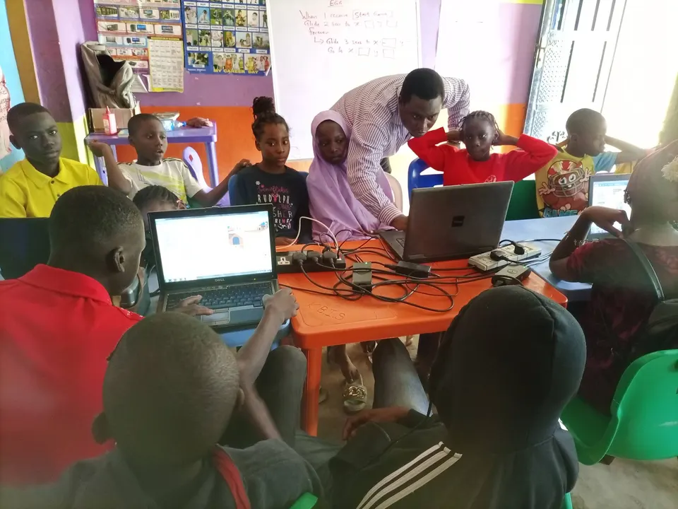 Children working on laptops and electronics at a community STEM session