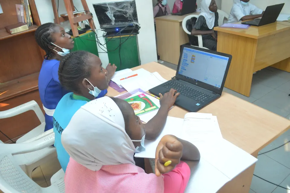 Girls working on Scratch at a laptop during International Day of the Girl 2021