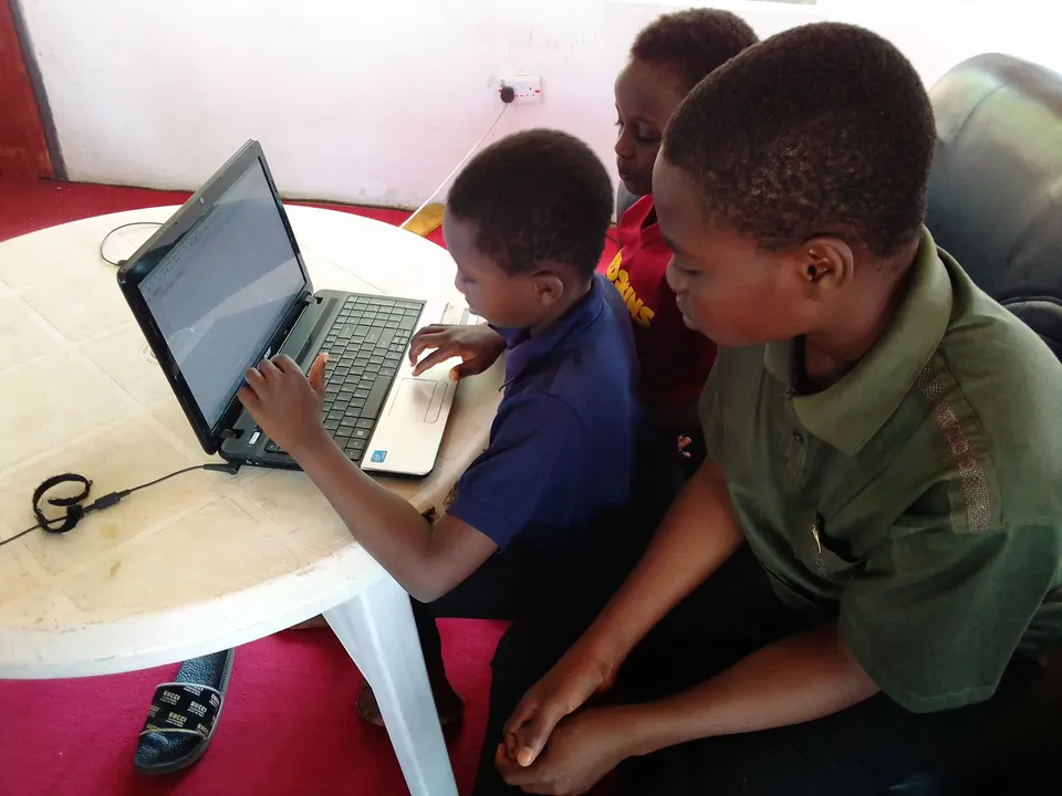 Two children sharing a laptop in a community STEM session