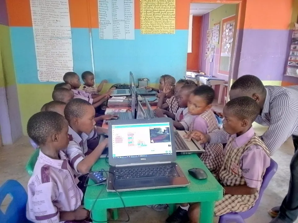 Young learners exploring Scratch together on one laptop