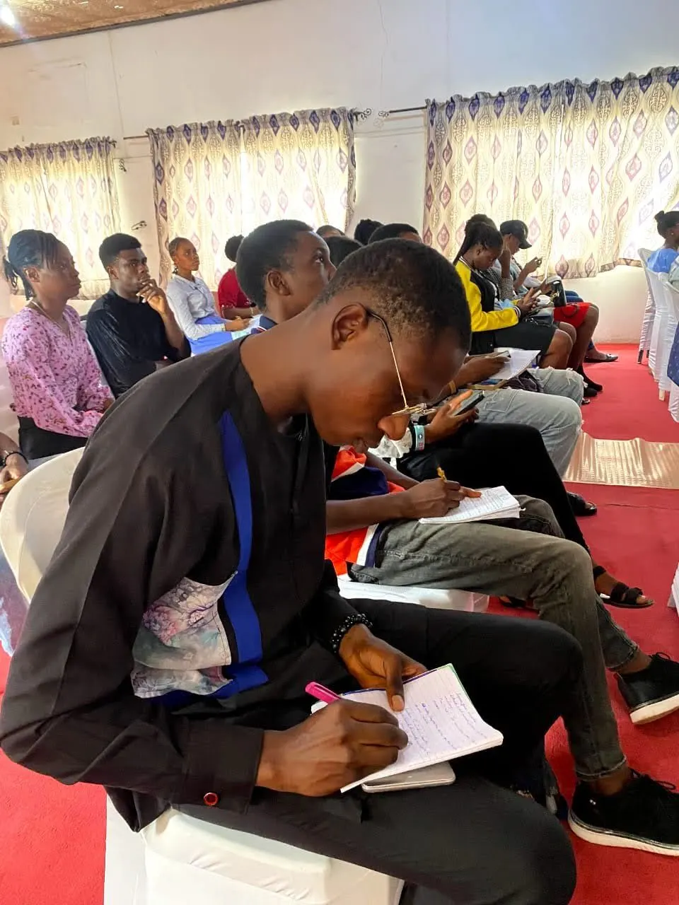 A young attendee taking notes at Rise Conference 1.0