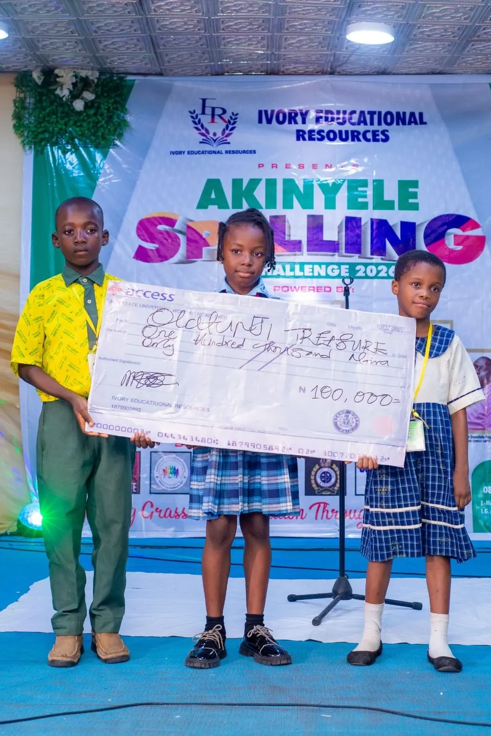 A winner of the Akinyele Spelling Challenge 2026 holding her prize